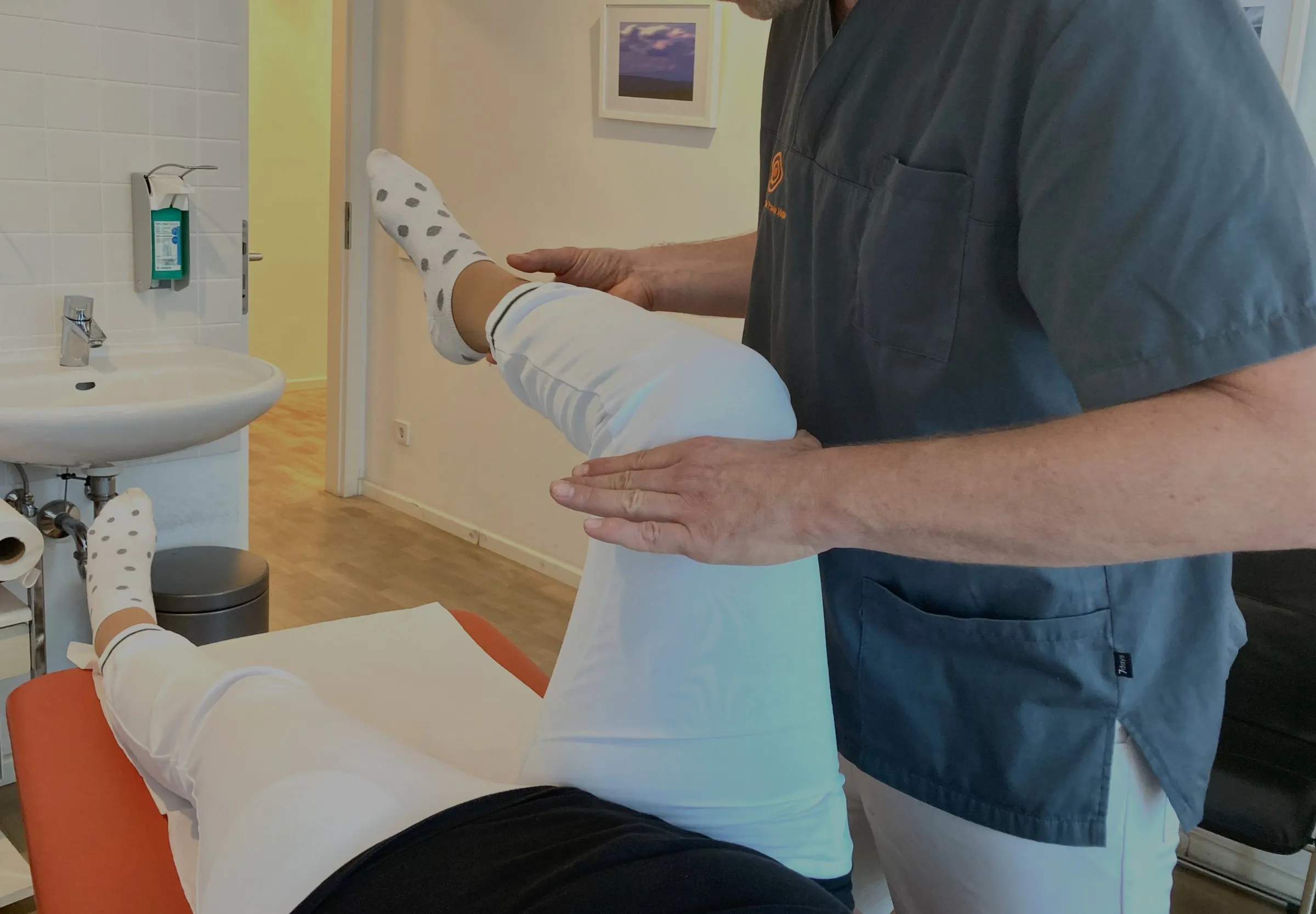 Muskeltest nach Applied Kinesiology am Bein einer liegenden Patientin